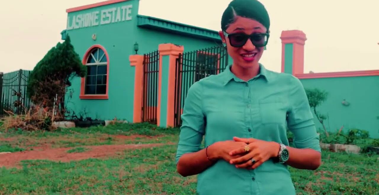 A Lashone TV presenter filming on location outside a Lashone estate