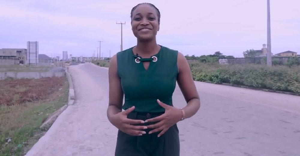 A Lashone presenter on the paved access road to Lashone Estate, Sangotedo